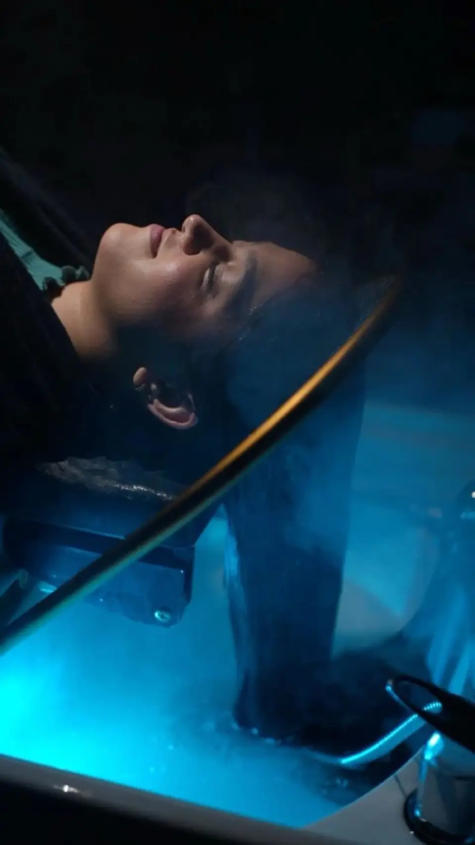 A client resting on the Korean water-fountain bed at Ally 21, hair flowing into lit running water